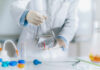 Scientist holding a flask filled with liquid in a laboratory setting