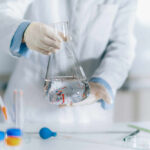 Scientist holding a flask filled with liquid in a laboratory setting