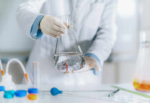 Scientist holding a flask filled with liquid in a laboratory setting
