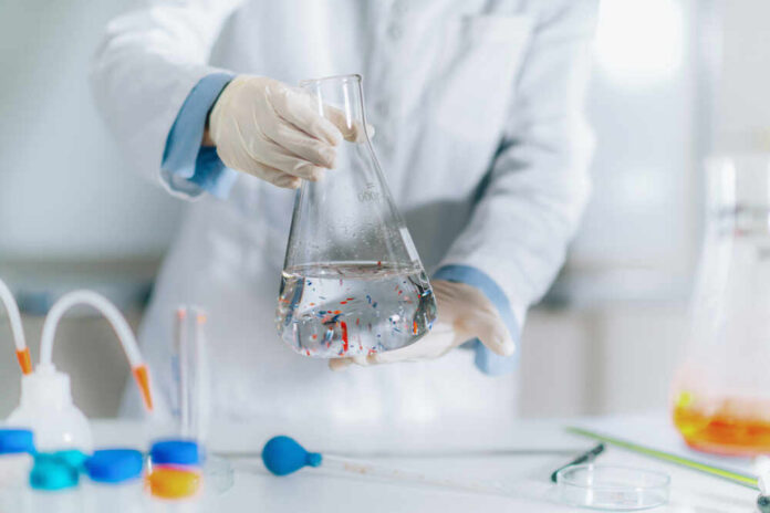 Scientist holding a flask filled with liquid in a laboratory setting