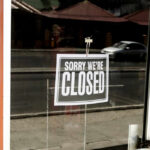 Closed sign hanging on a glass door