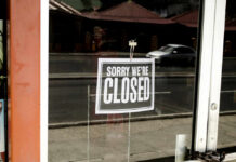 Closed sign hanging on a glass door