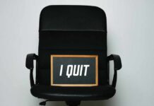 An office chair with a framed sign that says 'I QUIT'