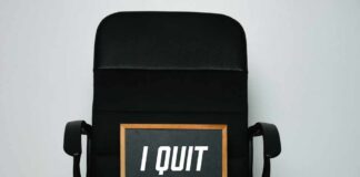 An office chair with a framed sign that says 'I QUIT'