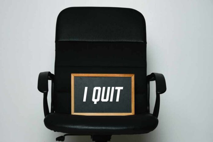 An office chair with a framed sign that says 'I QUIT'