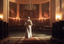 Pope’s Easter Message Differs From Previous Popes A religious figure standing in a church with candlelight illuminating the space