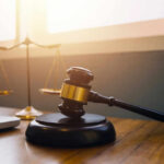 Gavel and scales of justice on desk.