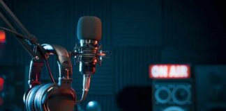 Microphone and headphones in a podcast studio with speakers in the background