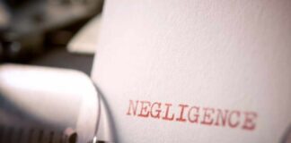 Close-up of a typewriter with the word 'NEGLIGENCE' typed on a sheet of paper