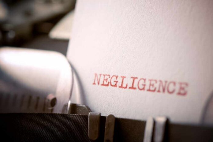 Close-up of a typewriter with the word 'NEGLIGENCE' typed on a sheet of paper