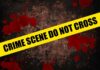 Yellow caution tape reading 'CRIME SCENE DO NOT CROSS' over a dark, blood-splattered background