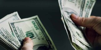 Hands holding and counting stacks of cash