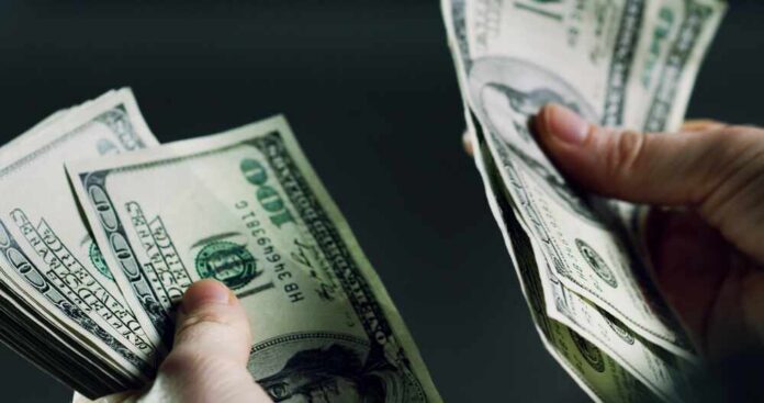 Hands holding and counting stacks of cash