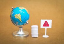 A miniature globe next to a warning sign and a barrel