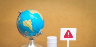 A miniature globe next to a warning sign and a barrel