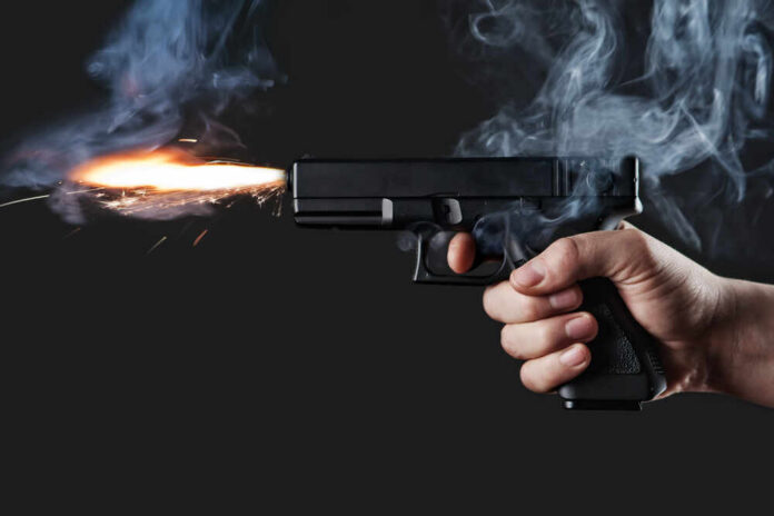 Shot,From,A,Handgun,With,Fire,And,Smoke A hand holding a gun with smoke and a flash from the muzzle