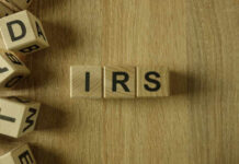 Wooden blocks arranged to spell 'IRS' on a wooden surface