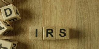 Wooden blocks arranged to spell 'IRS' on a wooden surface
