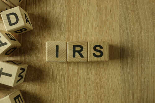 Wooden blocks arranged to spell 'IRS' on a wooden surface
