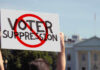 Voter Suppression Scandal: SHOCKING Map Fight Person holding No Voter Suppression sign outside White House.