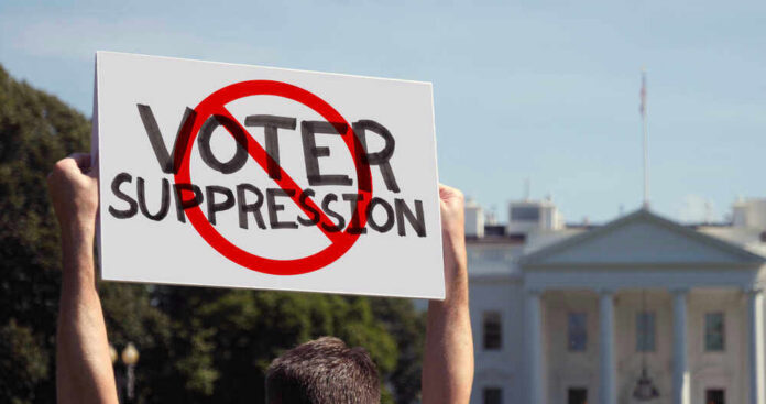 shutterstock_1984443866 Person holding No Voter Suppression sign outside White House.