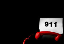 AI Kidnap Hoax: Mom Duped into $5,400 Scam A red telephone next to a sign displaying the number 911 on a dark background