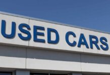 Sign displaying 'USED CARS' on a dealership building