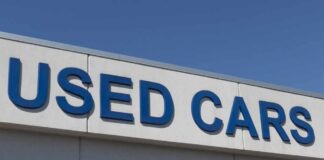 Sign displaying 'USED CARS' on a dealership building