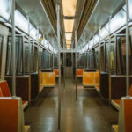 Subway Surfing Tragedy: Teen Falls to Death Empty subway train with orange seats.