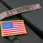 Military patches including a US Marines insignia and an American flag on a green surface