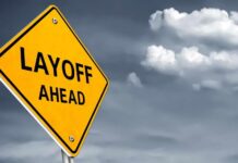 Massive Layoffs: AI’s Ruthless Takeover Yellow warning sign indicating layoffs ahead against a cloudy background