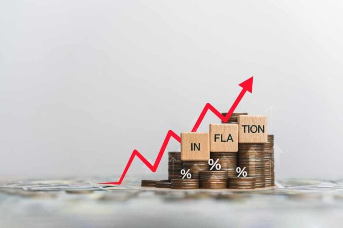 shutterstock_2505324085.jpg Graph showing inflation trend with coins and wooden blocks
