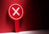 Tribal Uprising Stops Mining Project Red sign with a white 'X' symbol against a dark background