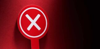 Red sign with a white 'X' symbol against a dark background