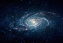 A spiral galaxy surrounded by stars in a dark space background
