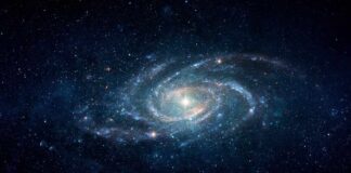 A spiral galaxy surrounded by stars in a dark space background