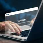 Person typing on a laptop with a search bar overlay