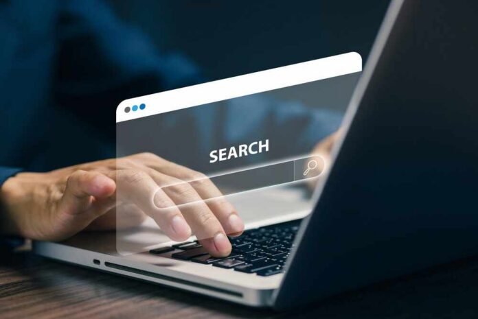 Person typing on a laptop with a search bar overlay
