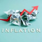 Crumpled dollar bills with a red upward arrow and the word 'INFLATION'