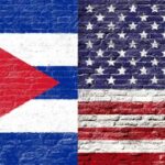 Raúl Castro Indictment Looms: Justice at Last? Cuban and American flags painted on a brick wall