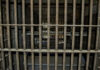 Execution Raises Eyebrows Empty, rusty barred jail cell with metal bunks.