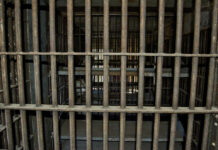 Execution Raises Eyebrows Empty, rusty barred jail cell with metal bunks.