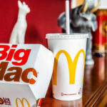 A Big Mac box and a McDonald's drink on a wooden table