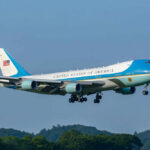 Foreign Gift Fuels Air Force One Uproar Airplane flying above trees with blue sky background