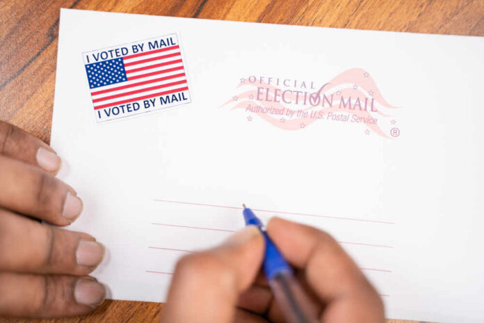 Hands addressing an official election mail envelope