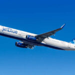 Mystery Hit Stuns JetBlue Landing An airplane approaching for landing against a colorful sunset sky