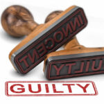 Two rubber stamps labeled guilty and innocent on a white surface