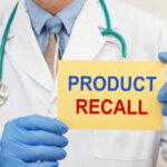 Medication Pills Recalled Nationwide Doctor holding a product recall sign in gloves