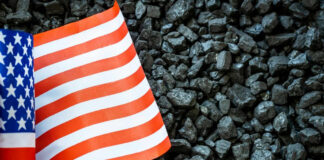 US flag on pile of dark coal rocks