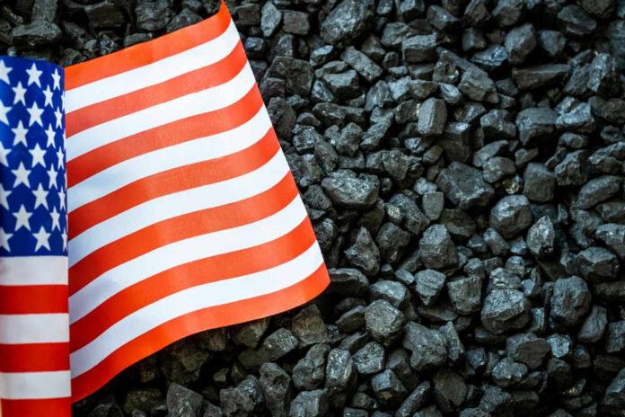shutterstock_2161696223 US flag on pile of dark coal rocks